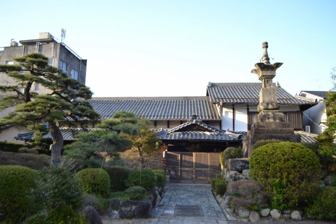 Privatus japoniškas sodelis daugiaaukščių namų apsuptyje.